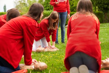 Schülerinnen und Schüler zeigen zum Welttag der Wiederbelebung 2025 wie eine erfolgreiche Reanimation funktioniert.