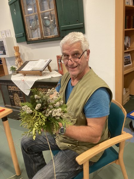 Ein Bewohner hält stolz sein Werk in die Kamera und grinst.