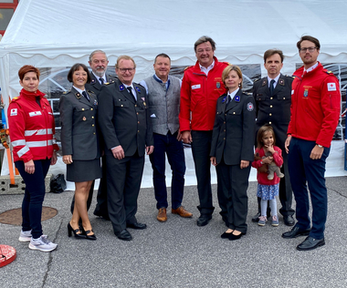 Foto von 9 Leuten draußen, Am Bild v.l.n.r.: Bezirksstellengeschäftsführerin Kirchschlag Gerlinde Pernsteiner, Bereichsgeschäftsführer Thomas Pointner mit Gattin Judith, Bürgermeister und Bezirksstellenleiter Kirchschlag Pepi Freiler, Bürgermeister Hollenthon Manfred Grundtner, Rot Kreuz Präsident Josef Schmoll, Ortsstellenleiterin Hollenthon Martina Ungermann, Bezirksstellengeschäftsführer Neunkirchen Horst Willesberger mit seiner Tochter, Bezirksstellenleiter Neunkirchen Gregor List
