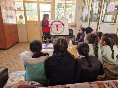 Eine Rotkreuz-Mitarbeiterin klärt Schülerinnen im Libanon über Menstruationshygiene auf.