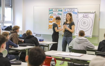 Zwei Peers tragen in einer Schulklasse vor zum Thema psychische Gesundheit.