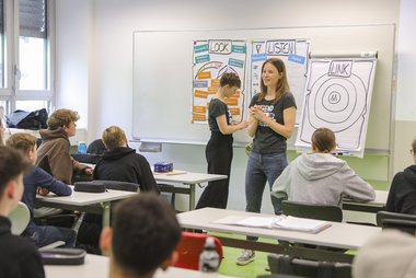 Zwei Peers tragen in einer Schulklasse vor zum Thema psychische Gesundheit.