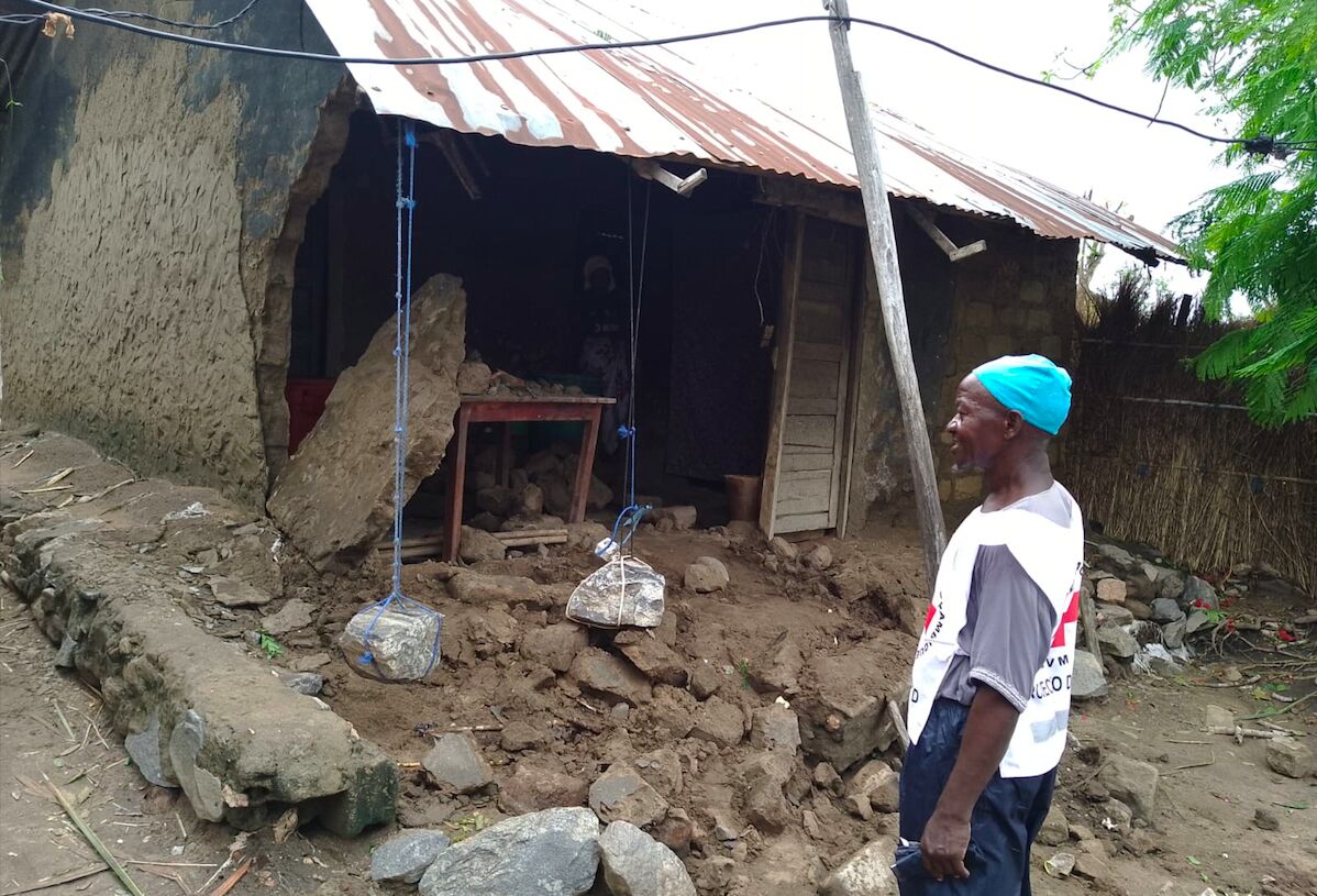 © Cruz Vermelha de Moçambique Mitarbeiter des Roten Kreuzes steht vor einem kaputten Haus in Mozambik nach Wirbelsturm Chido