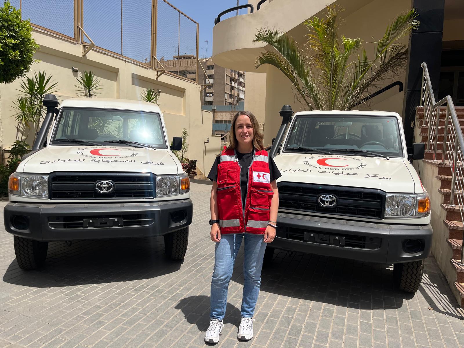 Teresa Mayr vor zwei Rotkreuzautos in Ägypten