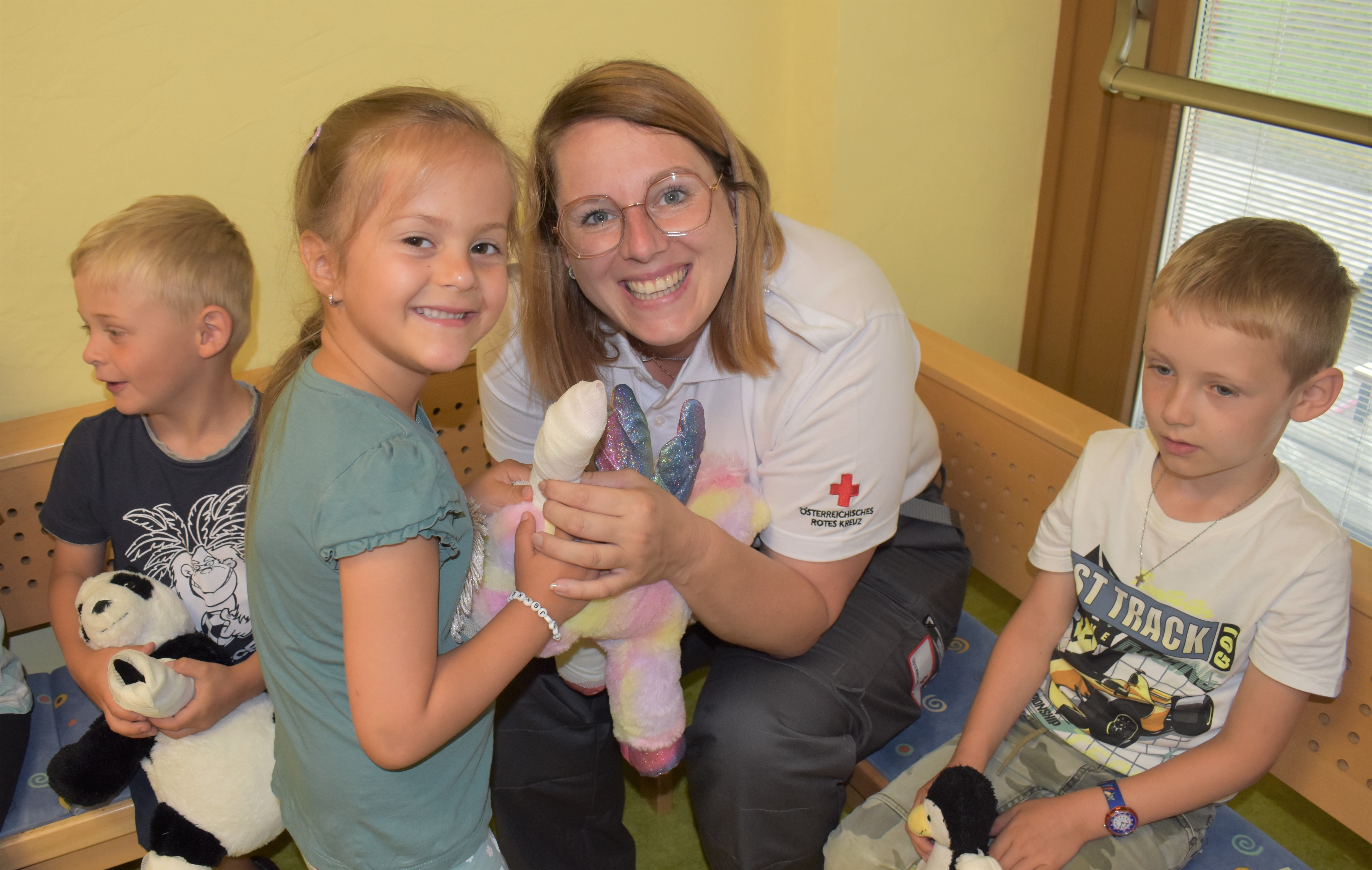 Eine Sanitäterin gemeinsam mit lachenden Kindern
