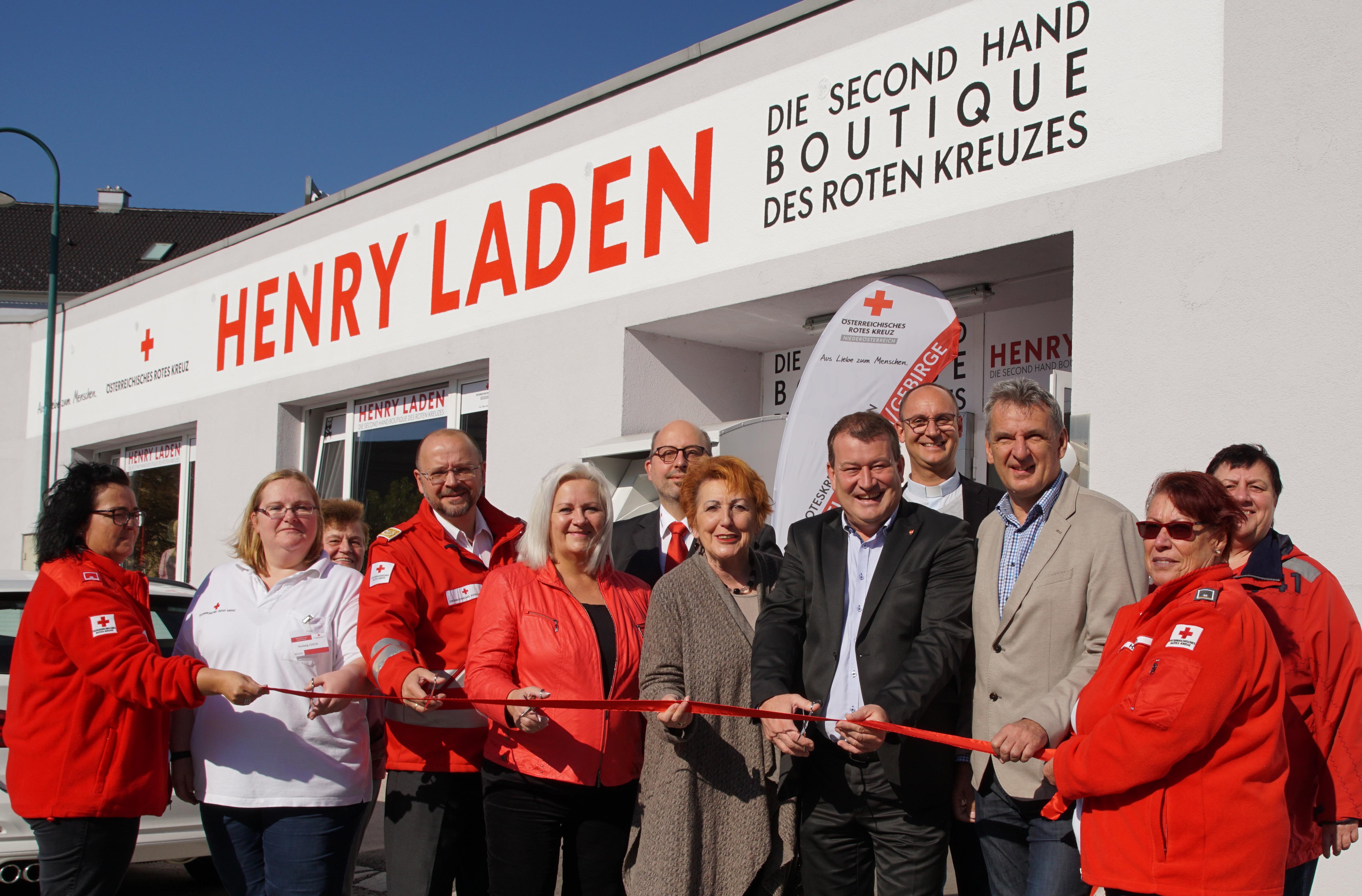 Eröffnung des Henry Laden in Brunn am Gebirge. Politiker und Rotkreuzmitarbeiter durchschneiden das Rote Eröffnungsband.