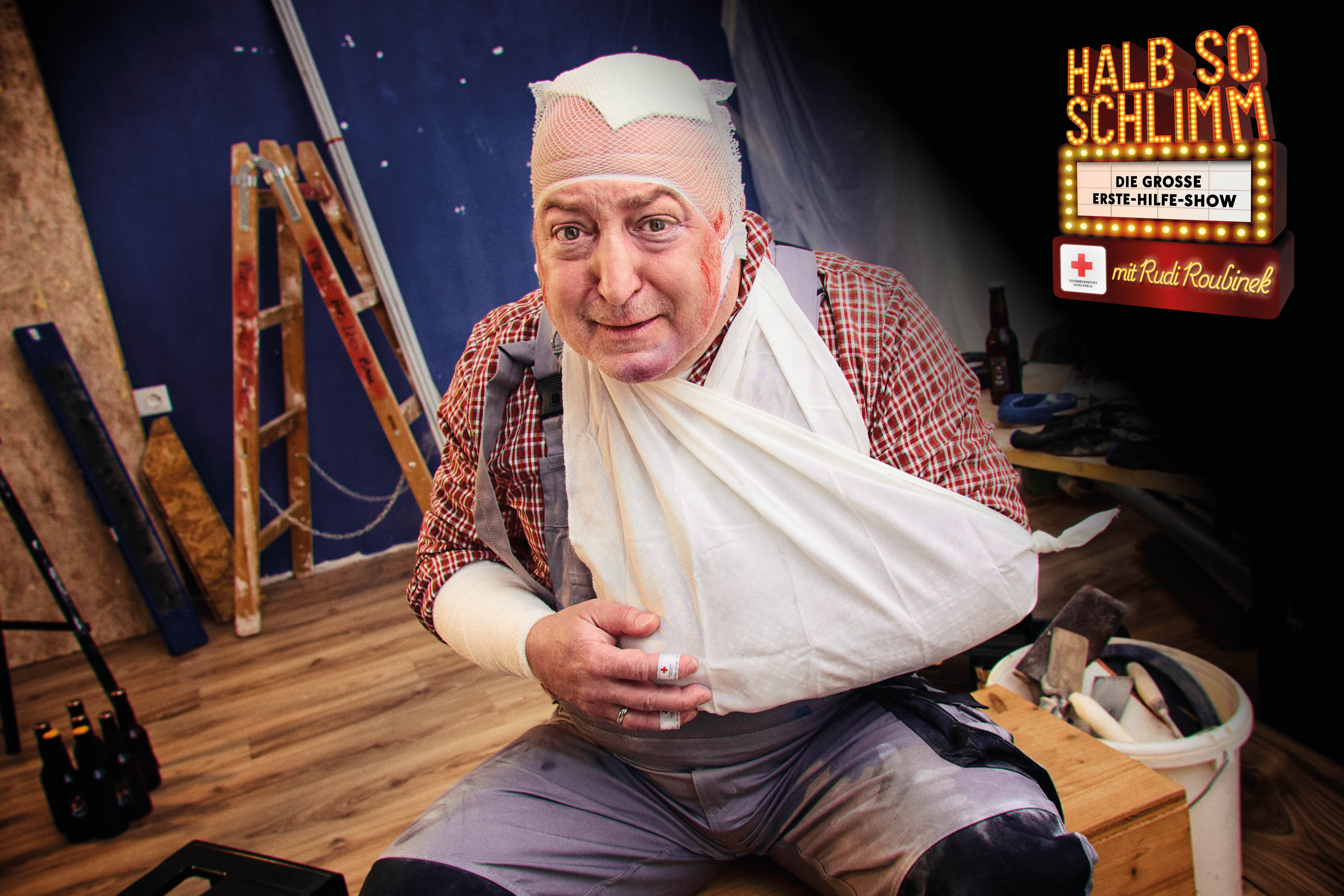 Rudi sitzt mit verbundenem Kopf und Arm mitten in einer Bausstelle.