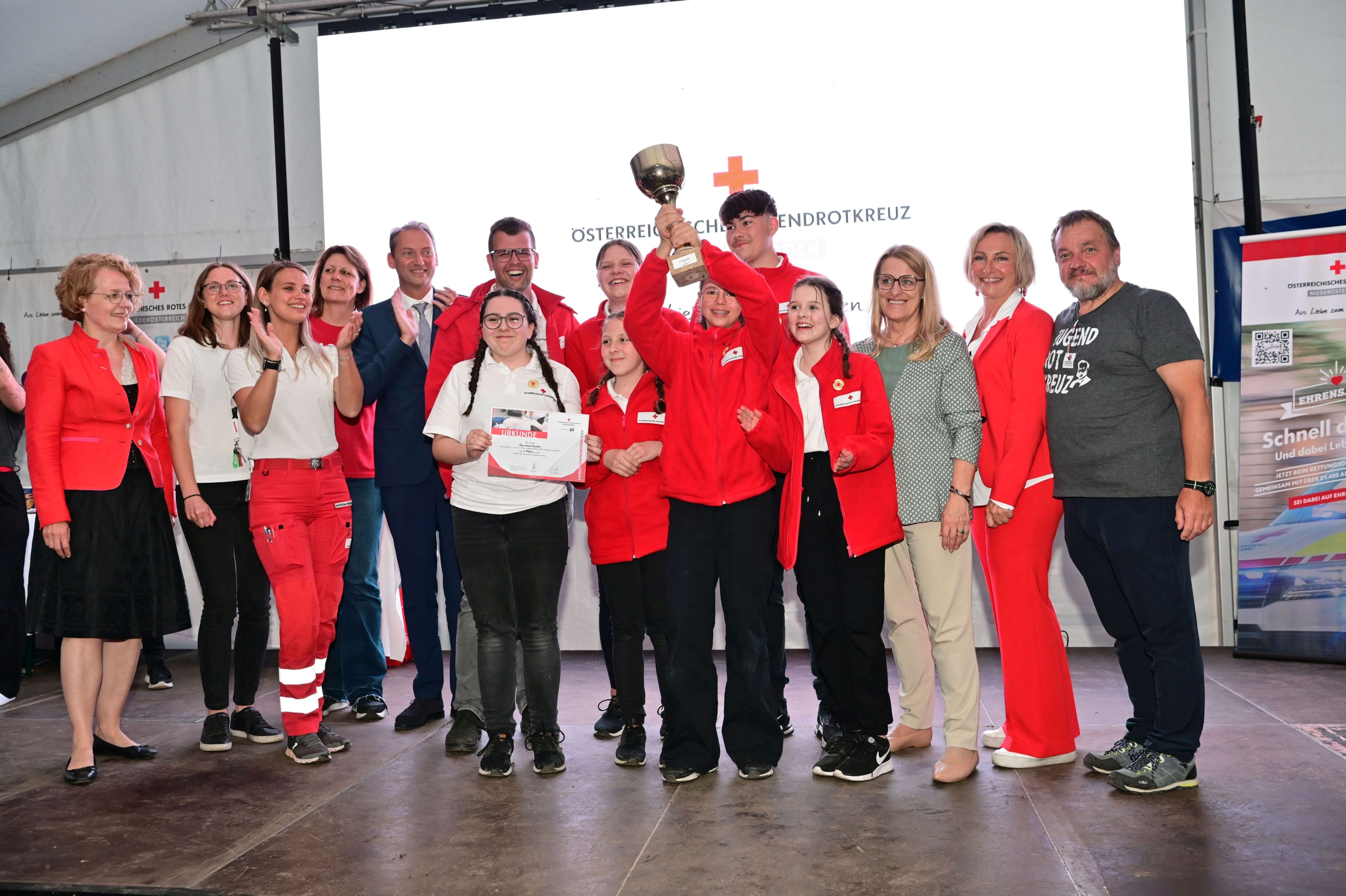 „Die roten Genies“ vom Roten Kreuz Allentsteig freuen sich über ihren Sieg in der Kategorie in Erste Hilfe Gold – im Foto (v.l.n.r.) Landesrätin Christiane Teschl-Hofmeister, Jill Bigler, Georgia Praska, Rotes Kreuz NÖ, Landesjugendreferentin Gudrun Chwojka, Jugendrotkreuz NÖ, Eric-René Steininger, NÖ Versicherung, das Team „Die roten Genies“ vom Roten Kreuz Allentsteig mit ihrem Betreuer, Landesrätin Ulrike Königsberger-Ludwig, Landesleiter-Stellvertreterin Sylvia Graser, Jugendrotkreuz NÖ und Präsident Hans Ebner, Rotes Kreuz NÖ