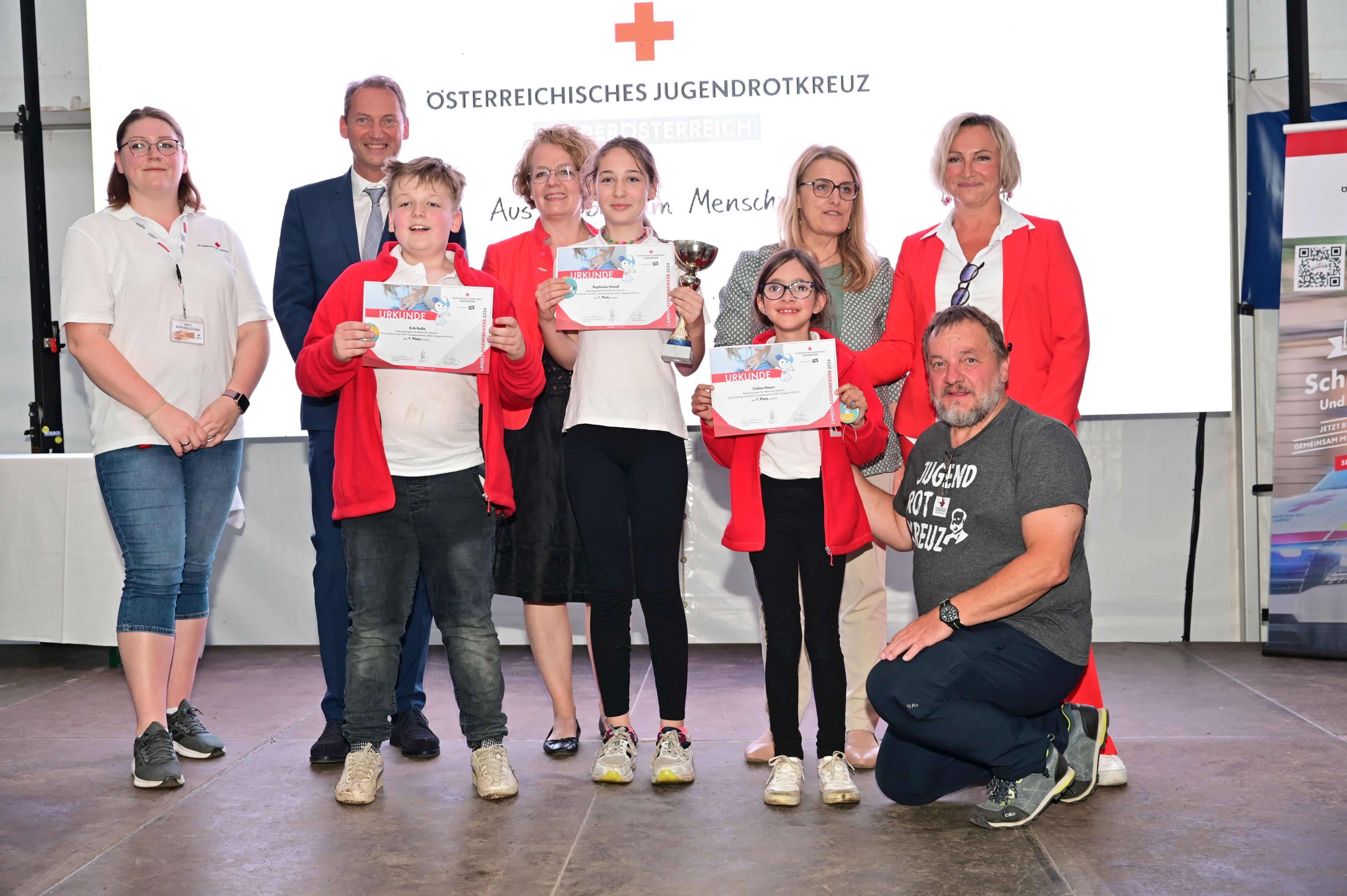 Gewinnergruppe Helfi 2+ (bis 14 Jahre, mind. ein Kind unter 10 J) „Die Retter der Zukunft 1“ vom Roten Kreuz Gföhl (Bezirksstelle Krems) freuten sich über den ersten Platz im Bewerb Helfi 2+ - im Foto mit (v.l.n.r.) Katharina Gahr, Rotes Kreuz NÖ, Eric-René Steininger, NÖ Versicherung, Landesrätin Christiane Teschl-Hofmeister, Landesrätin Ulrike Königsberger-Ludwig und Landesleiter-Stellvertreterin Sylvia Graser, Jugendrotkreuz NÖ, im Vordergrund „Die Retter der Zukunft 1“ mit Rotkreuz-Präsident Hans Ebner