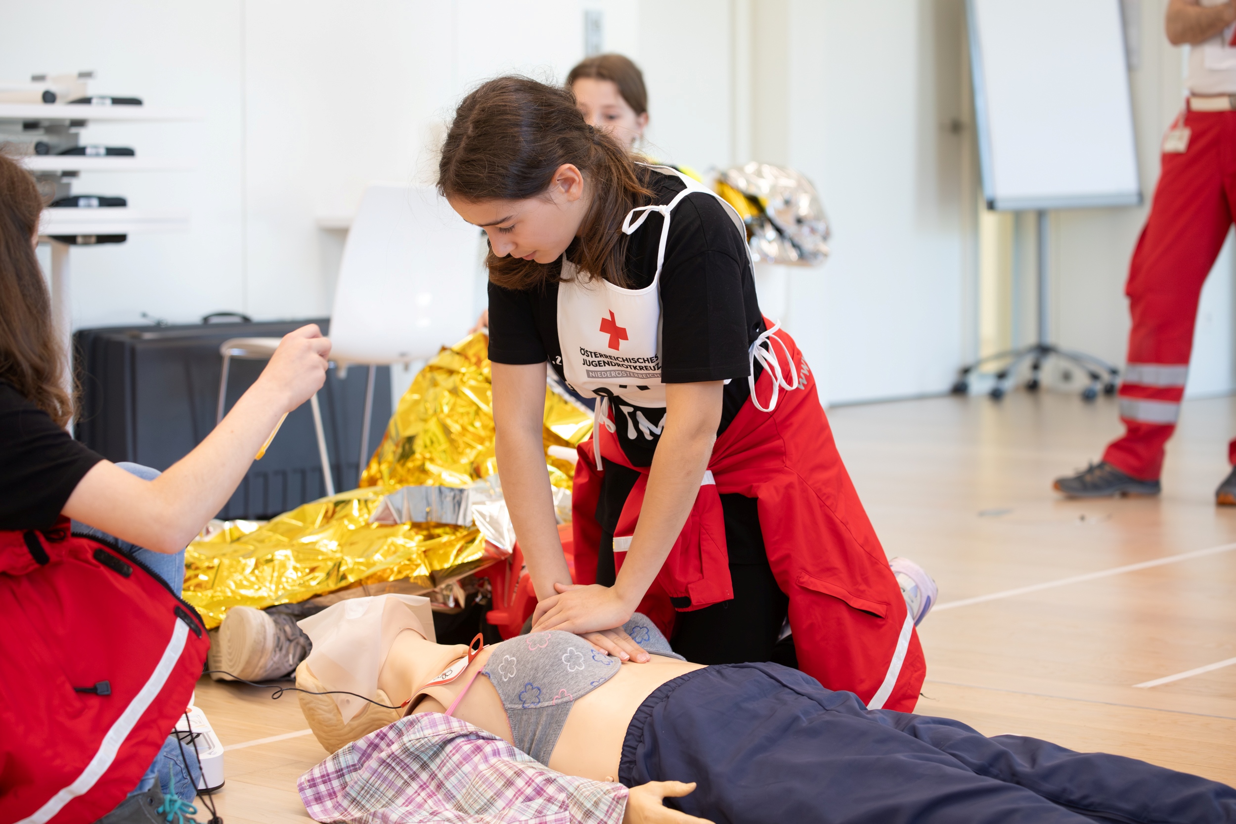 Ein Kinder übt die Reanimation an einer Puppe.