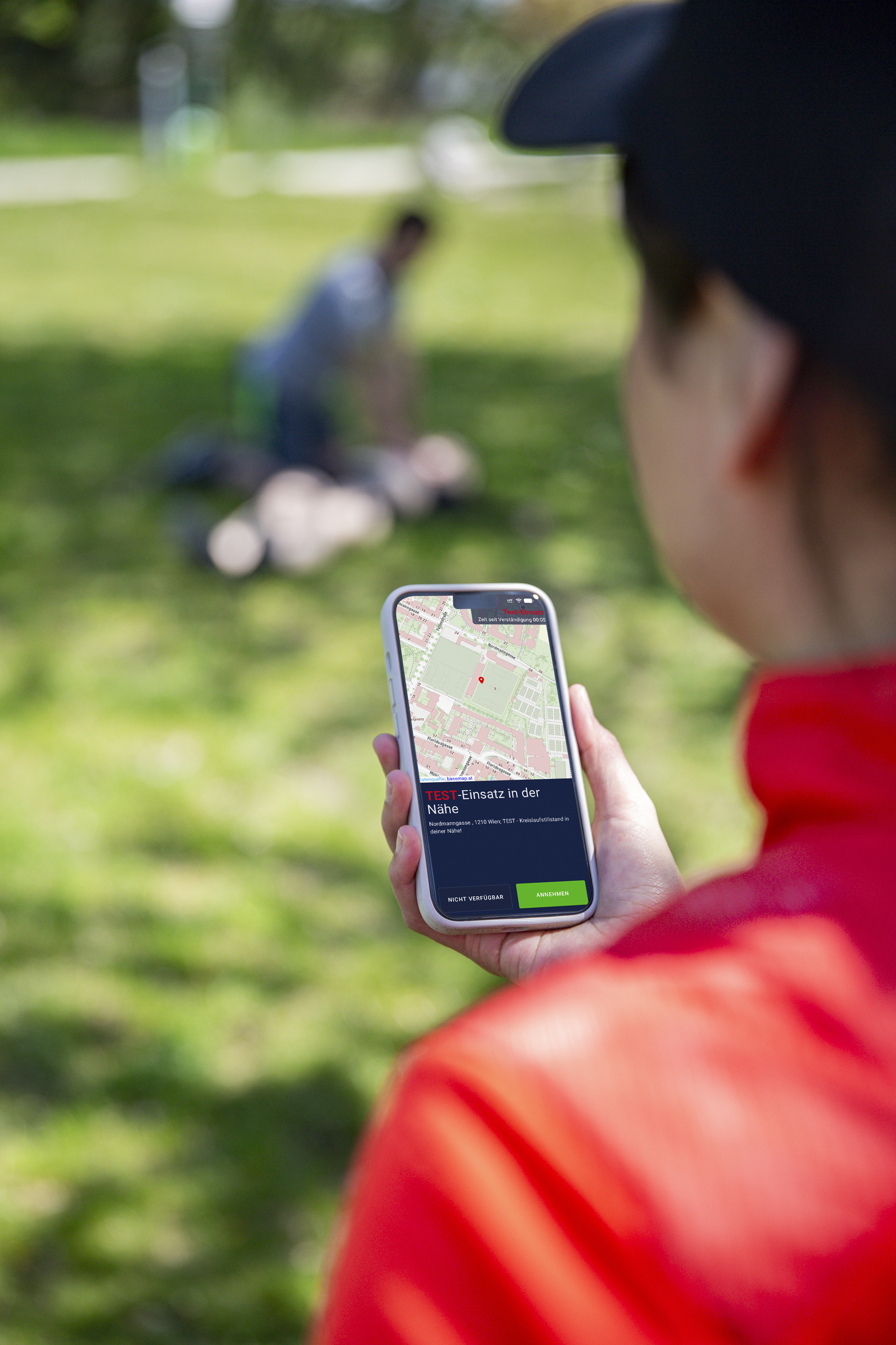 Eine Person hat ein Handy in der Hand und die Lebensretter:innen-App offen.