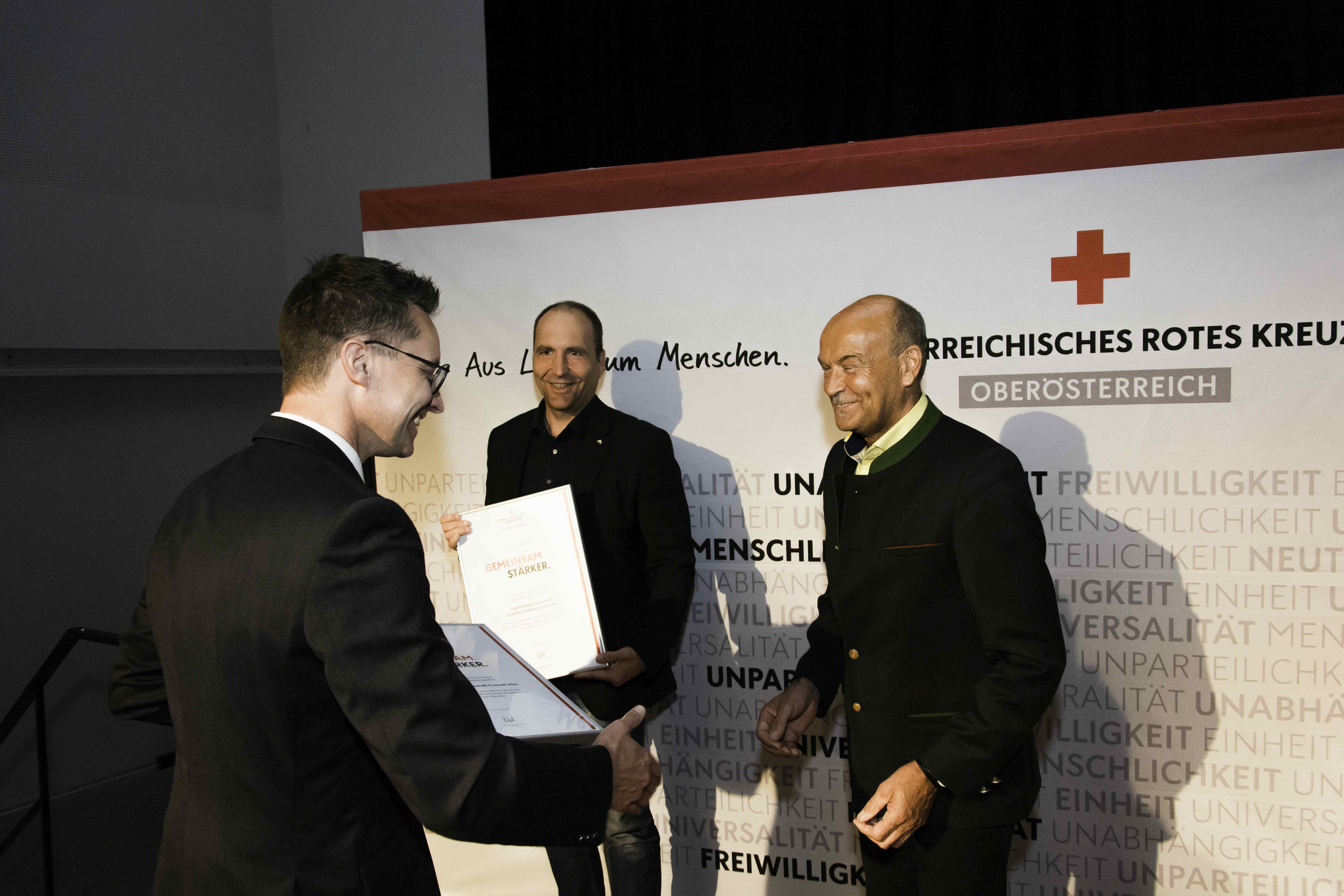 : Dir. Hannes Ranetbauer und sein Kollege Dir. Leopold Piererfellner bekommen von Bezirksgeschäftsleiter Gerald Roth im Rahmen der diesjährigen Bezirksstellenversammlung die Kooperationsurkunde überreicht