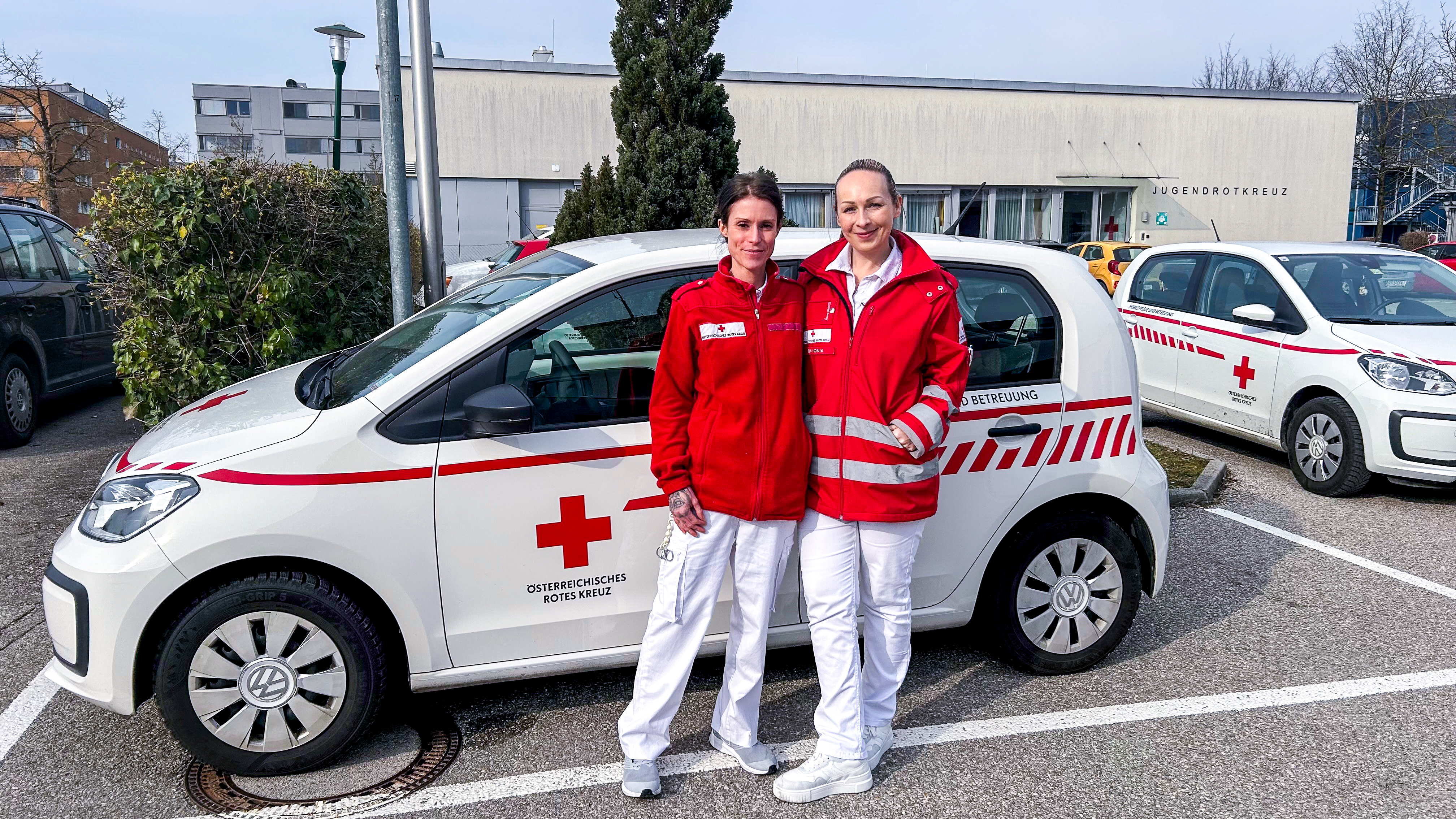 Sonja und Barbara stehen in Uniform vor einem ihrer Dienstautos
