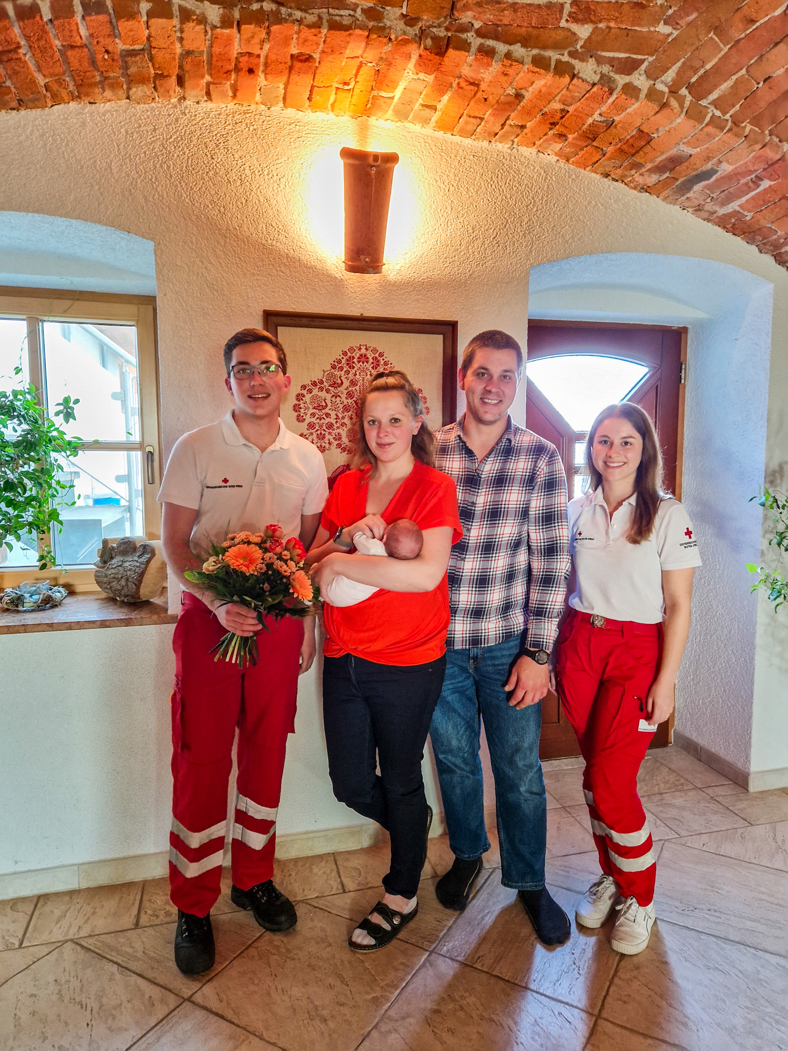 Geburt B1 - © RK Lambach Familie und Rettungsdienst-Team nach der Geburt in einem Rettungsauto am 18. April.