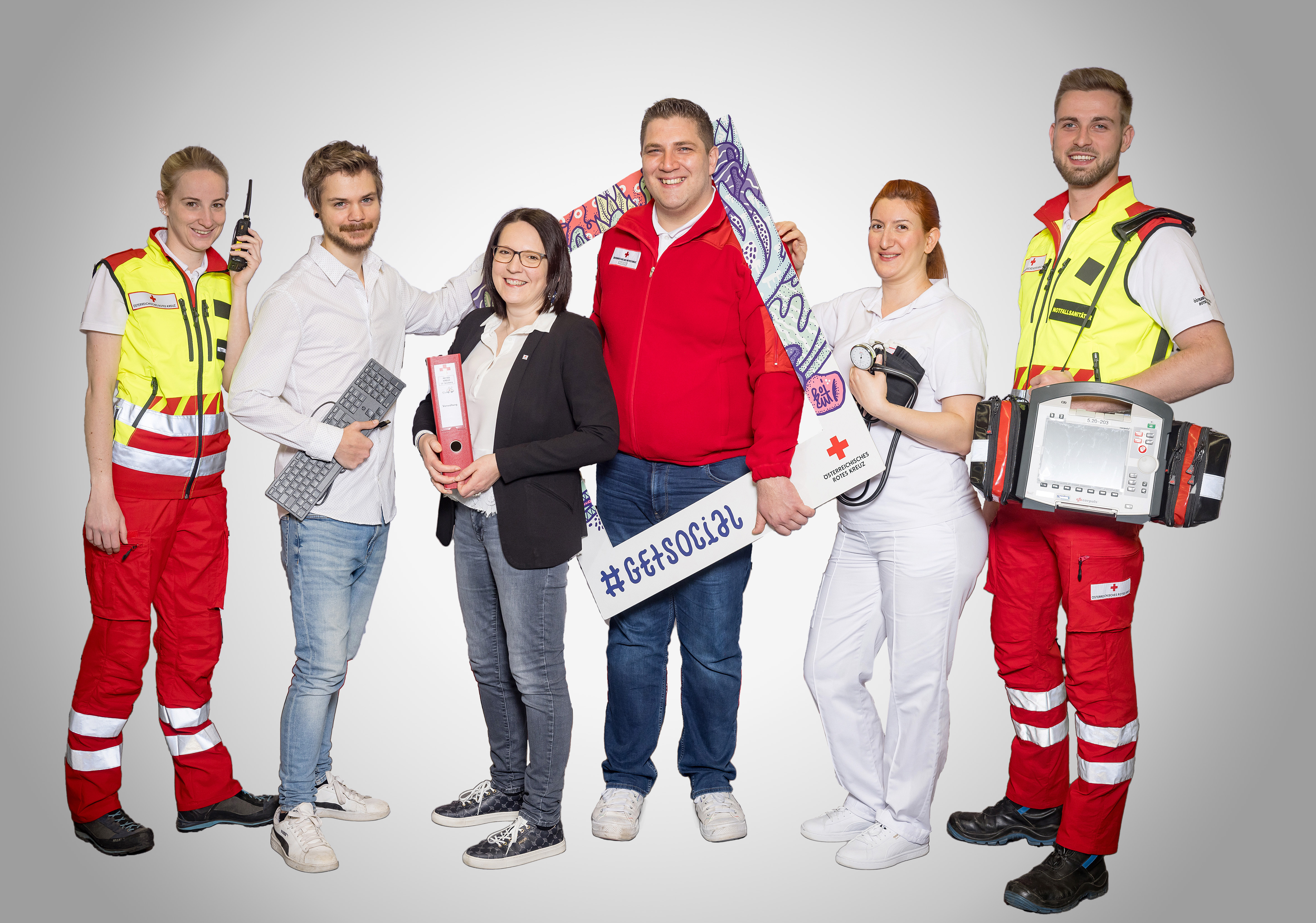 Teamfoto für Stellenausschreibungen, das unterschiedliche Tätigkeitsbereiche im Roten Kreuz zeigt