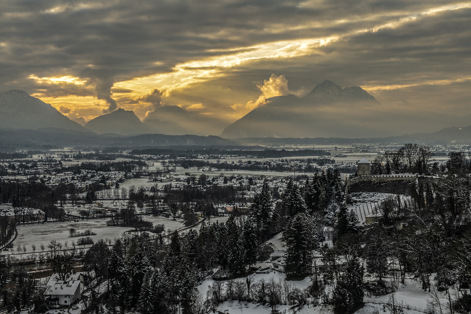 Bewölkte Landschaft mit Bergen im Hintergrund bei Sonnenuntergang