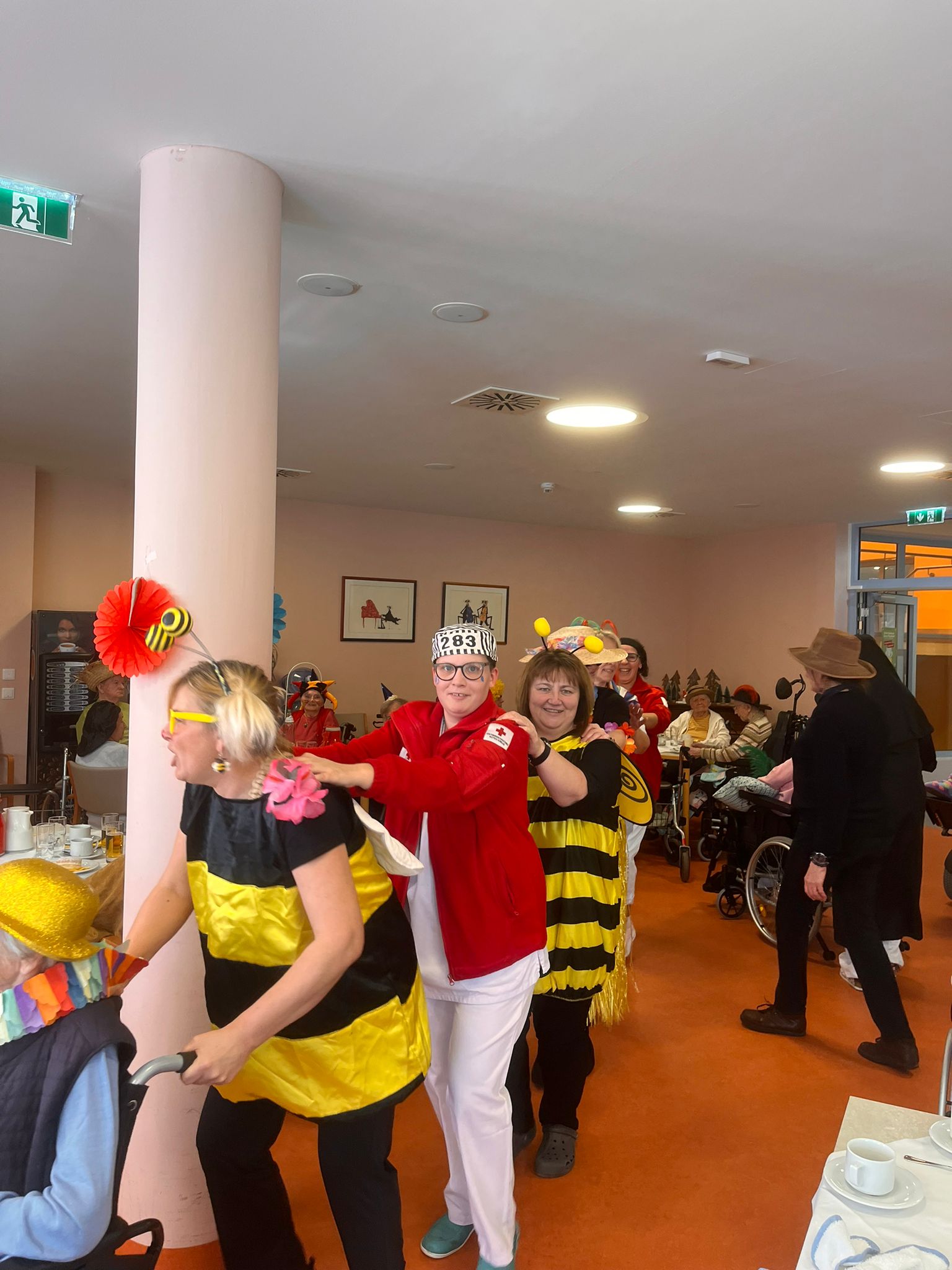 Kostümierte Bewohner:innen und Mitarbeiter:innen tanzen gemeinsam zu Fasching im Seniorenwohnhaus Puch.