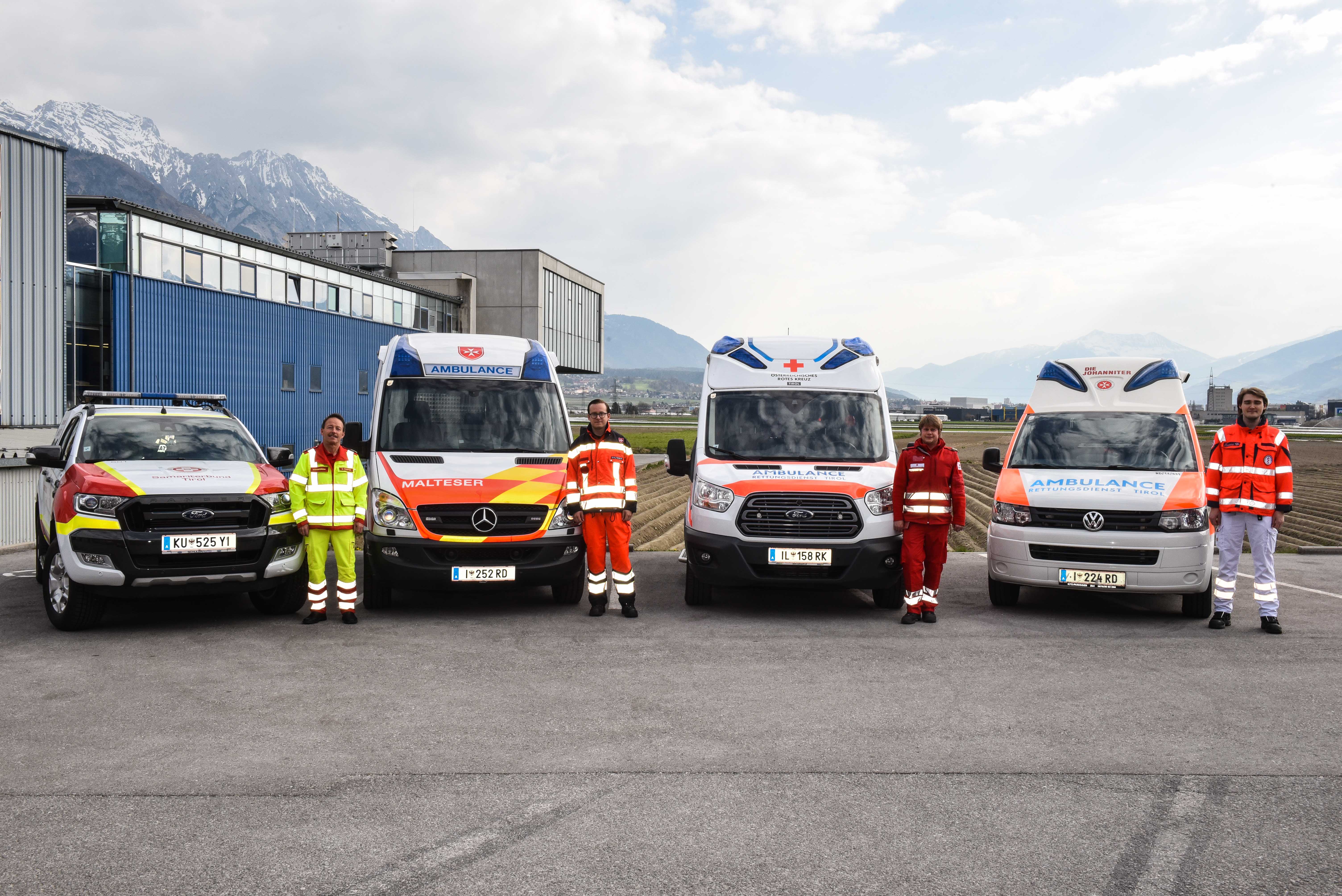 Die vier Fahrzeuge von Malteser, Johanniter, Samariter und Rotem Kreuz samt Fahrer in Uniform stehen in einer Reihe